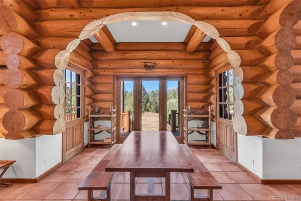 a dining room with a wooden table and chairs