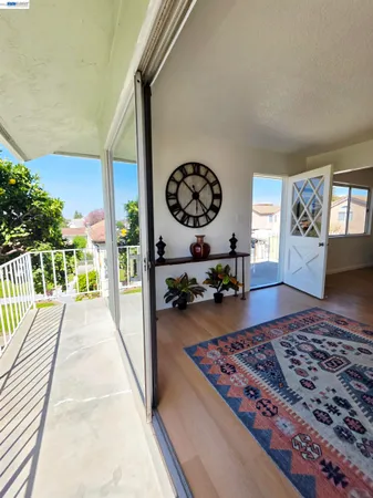 a living room with rug floor to ceiling window and a rug