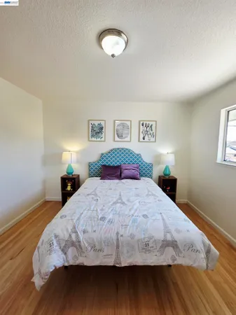 a bedroom with a bed and a wooden floor