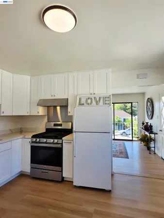 a kitchen with wooden floors a stove and a refrigerator