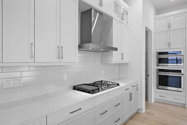 a kitchen with stainless steel appliances white cabinets and a stove