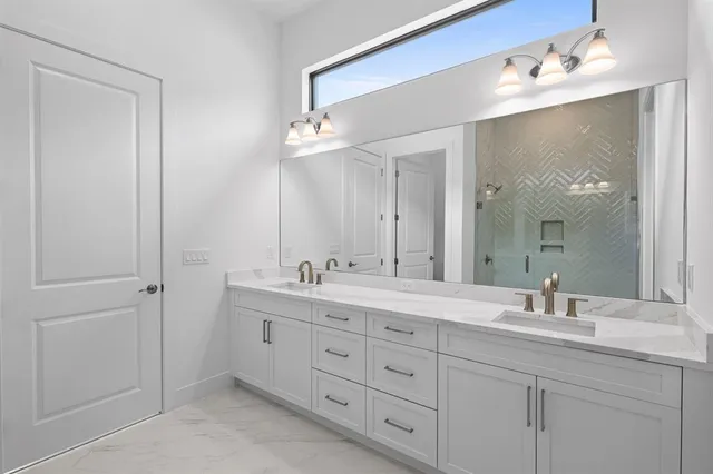 a bathroom with double vanity sink and a mirror