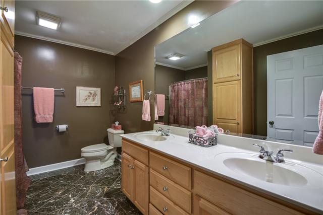 968 Sneed Road West Franklin, TN 37069 - Photo 17 of 20 A full bathroom is located downstairs. This room has a shower / tub combination, marble tiled floor and maple cabinets with storage for linen.