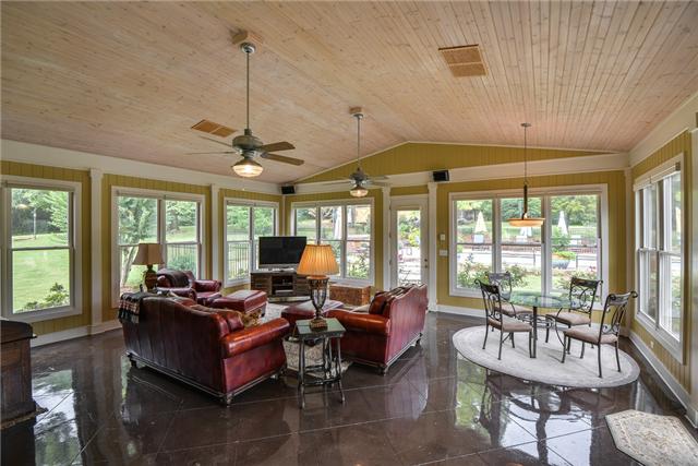 968 Sneed Road West Franklin, TN 37069 - Photo 5 of 20 WOW! The Living room is a huge Florida Room. Surrounded by windows, this room is sunny and bright with a panoramic view of the in-ground pool outside. The floor is scored concrete and the vaulted ceiling is paneled and enhanced by 2 ceiling fans.