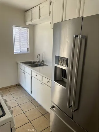 a kitchen with granite countertop a refrigerator and a sink