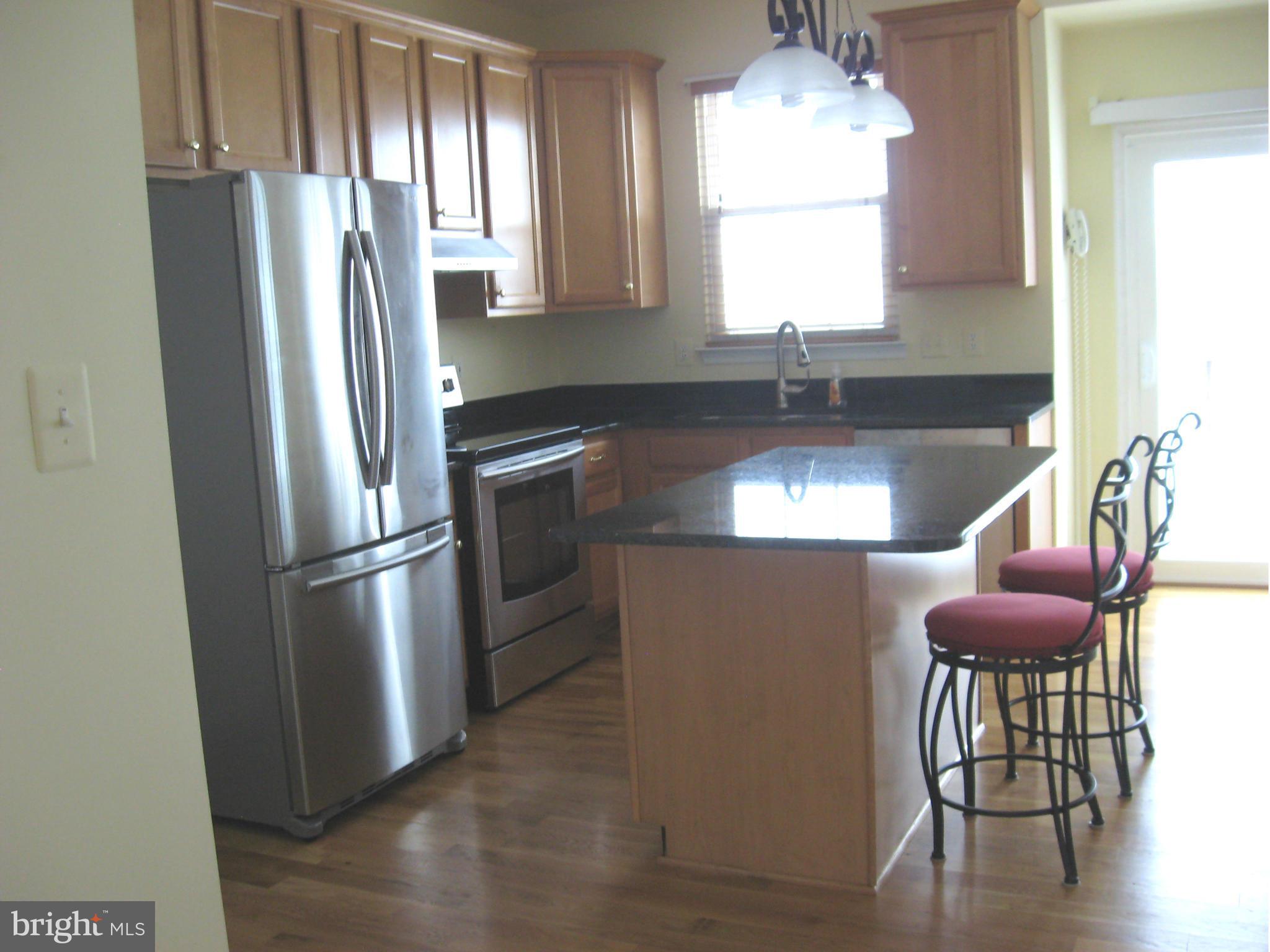 8822 Mapleville Road Mount Airy, MD 21771 - Photo 22 of 27 a kitchen with stainless steel appliances granite countertop a refrigerator a sink a stove and island