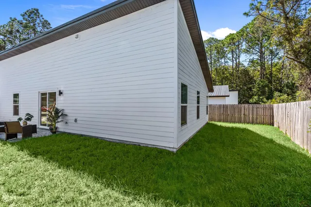 a view of backyard with potted plants and large tree