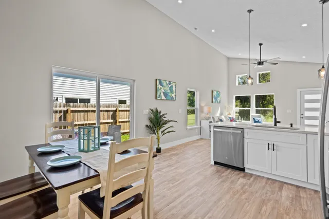 a living room with furniture a dining table and chairs with wooden floor
