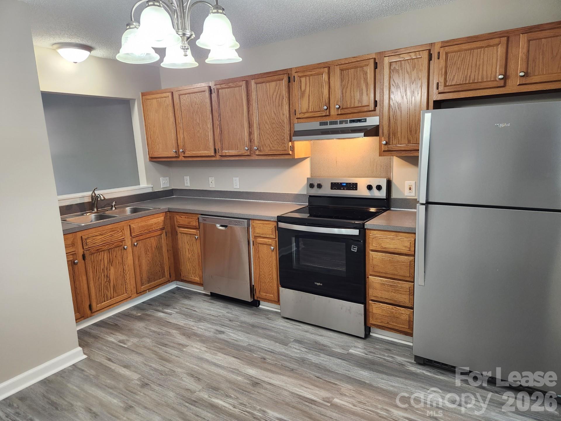159 Pounds Avenue Southwest Concord, NC 28025 - Photo 2 of 10 a kitchen with a refrigerator sink and cabinets