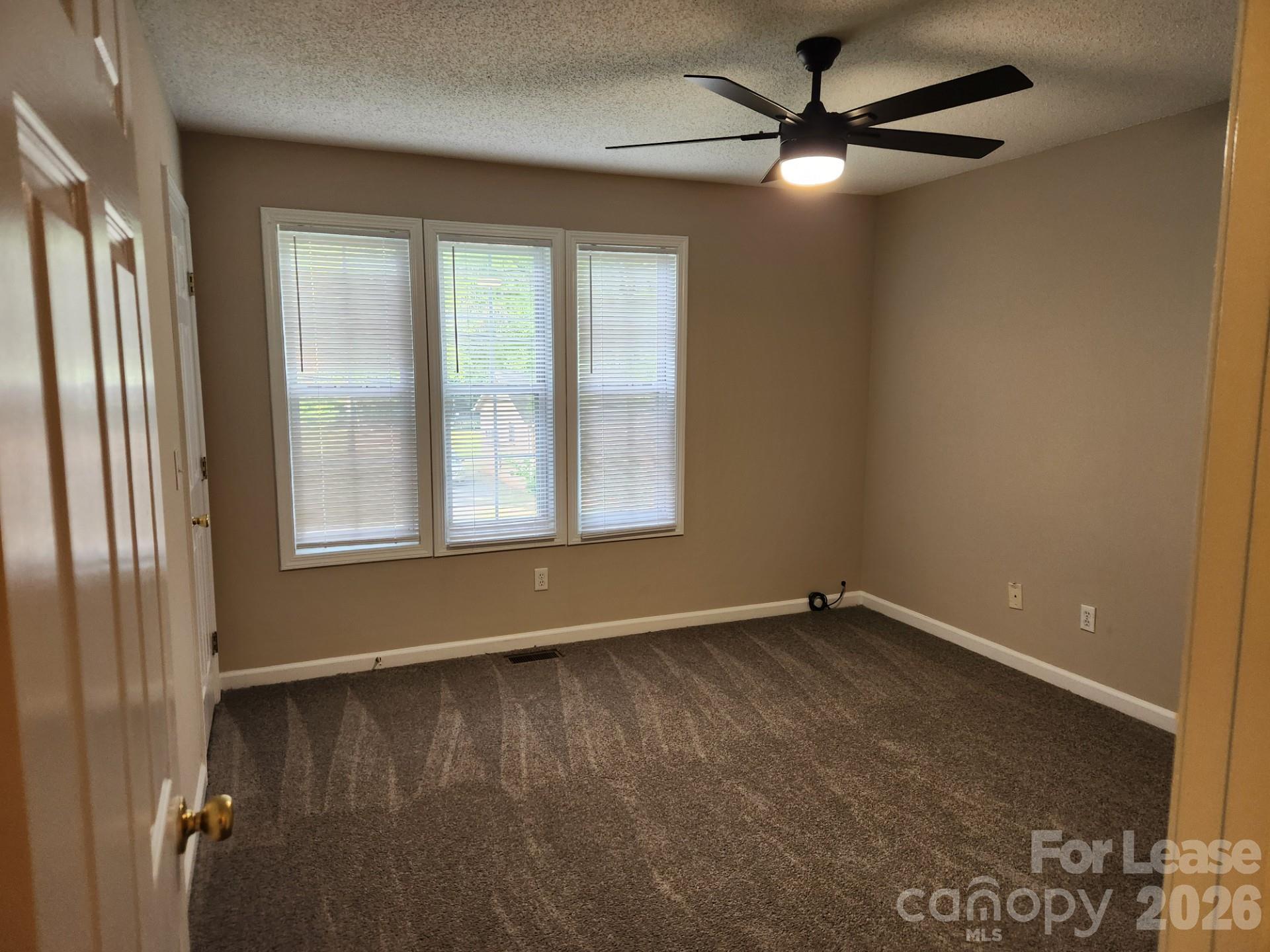 159 Pounds Avenue Southwest Concord, NC 28025 - Photo 8 of 10 a view of an empty room with a window and a chandelier fan