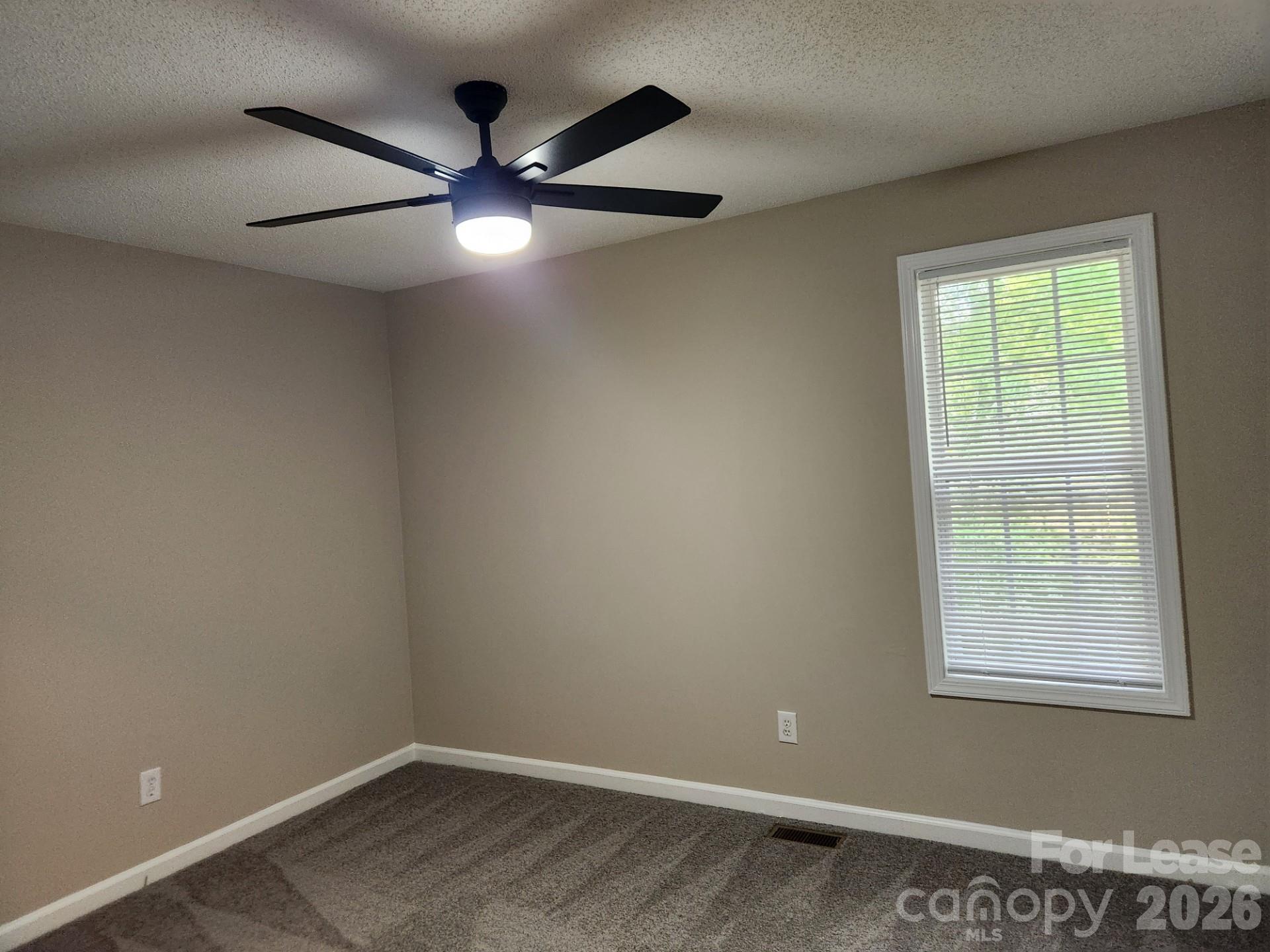 159 Pounds Avenue Southwest Concord, NC 28025 - Photo 9 of 10 an empty room with a window and a fan