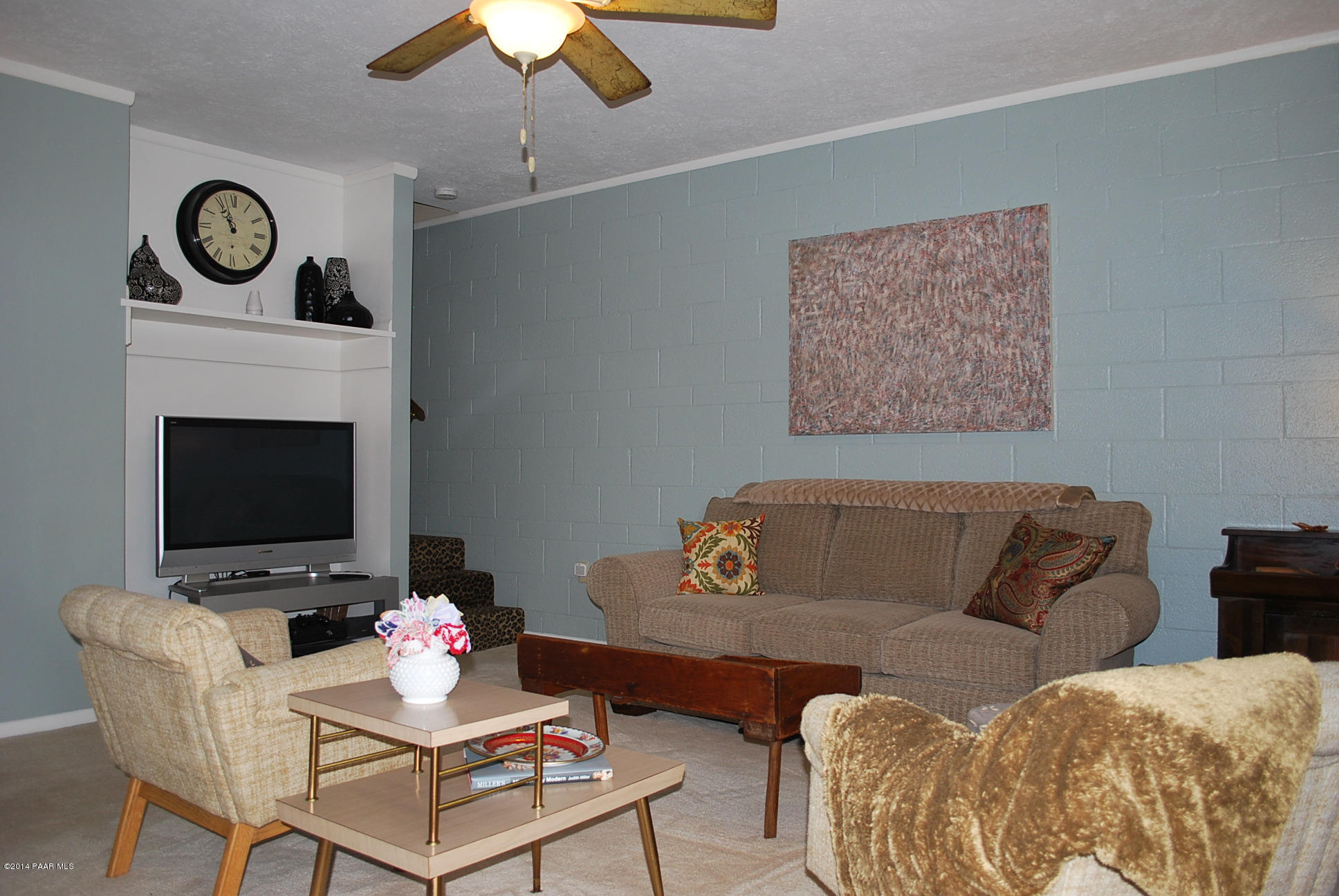 2701 Ridge Road Prescott, AZ 86301 - Photo 31 of 39 a living room with furniture a clock on wall and a fireplace
