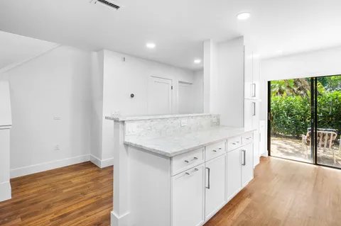 an empty room with wooden floor and a sink
