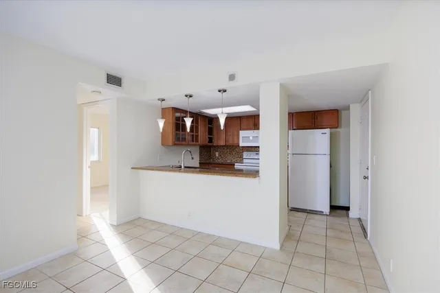 a view of a kitchen with wooden floor and a refrigerator