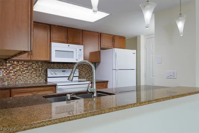 a kitchen with kitchen island a sink a stove and a refrigerator