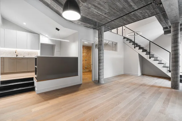 a view of an empty room with a window and stairs