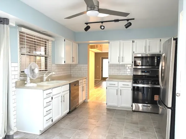 a view of a kitchen with a refrigerator and cabinets