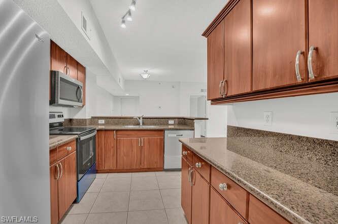 a kitchen with stainless steel appliances granite countertop a sink stove and cabinets
