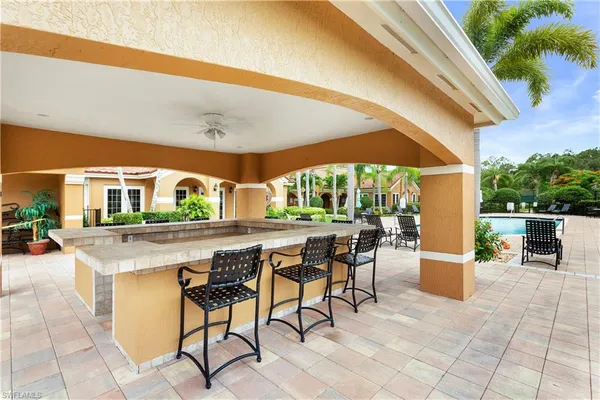 a view of a patio with a table and chairs under an umbrella