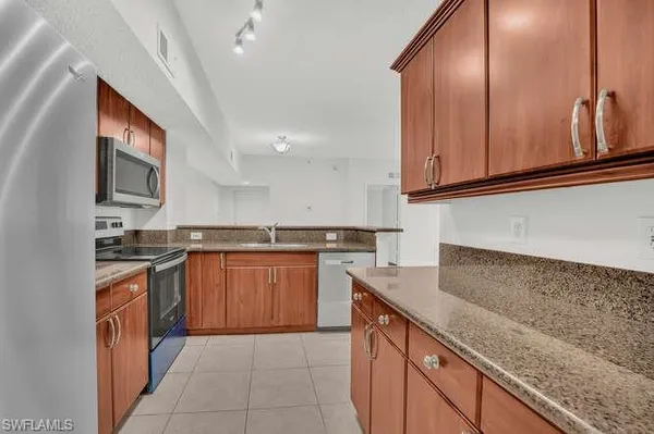 a kitchen with stainless steel appliances granite countertop a sink stove and cabinets