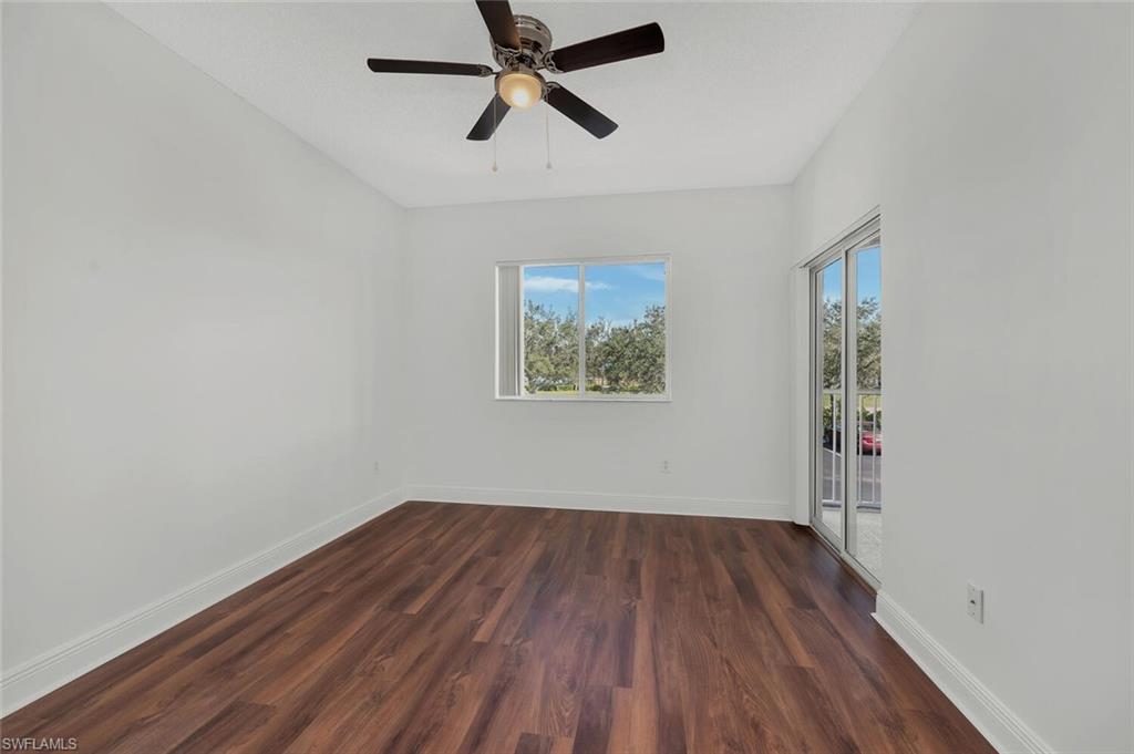 Undisclosed Address Naples, FL 34112 - Photo 4 of 23 an empty room with wooden floor ceiling fan and windows