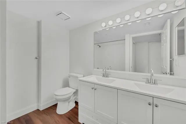 a bathroom with a toilet a sink and mirror