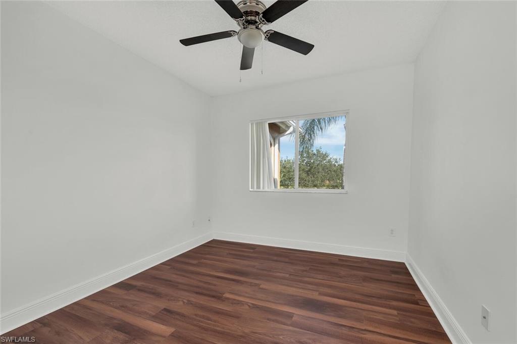 Undisclosed Address Naples, FL 34112 - Photo 6 of 23 a view of an empty room with wooden floor and a ceiling fan