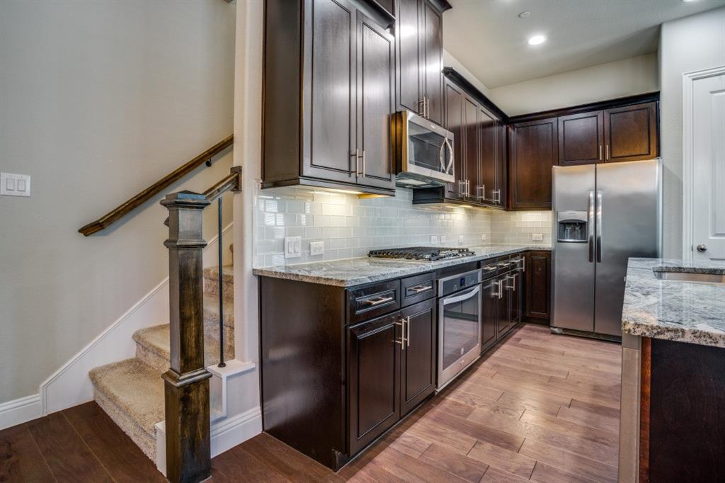 6120 Rilla Street Frisco, TX 75035 - Photo 6 of 20 a kitchen with stainless steel appliances granite countertop a stove and a refrigerator