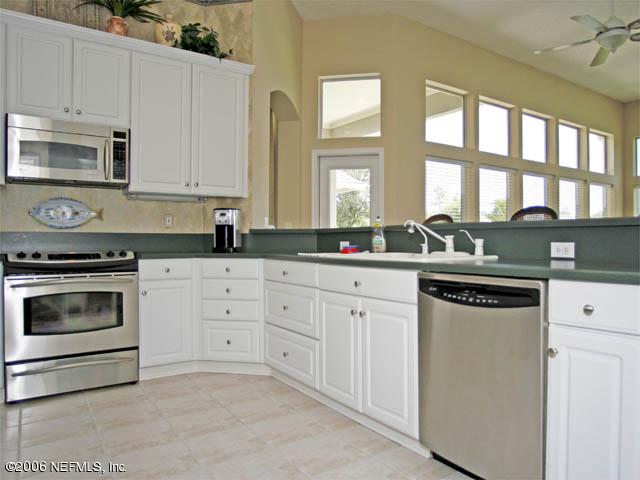 10027 Deercreek Club Road Jacksonville, FL 32256 - Photo 4 of 15 a kitchen with granite countertop white cabinets and a stove