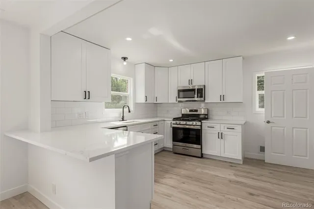 a kitchen with stainless steel appliances granite countertop a stove and white cabinets