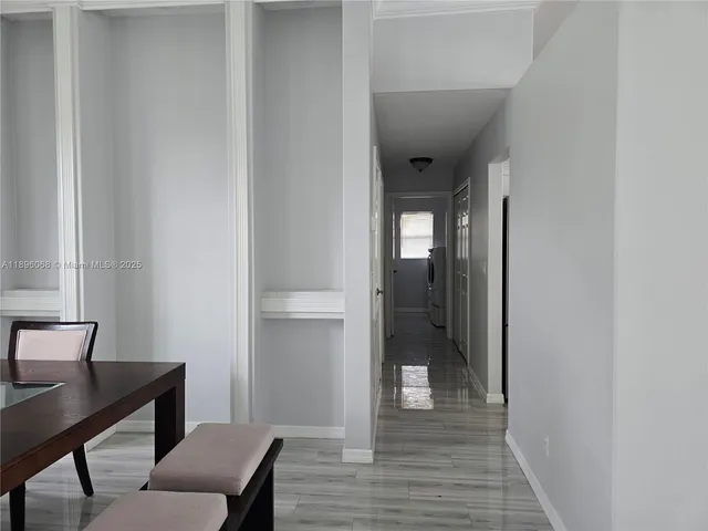 a view of a hallway with wooden floor and a workspace