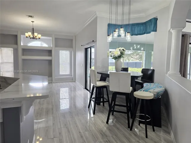 a view of a dining room with furniture a chandelier and wooden floor