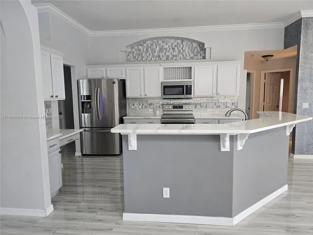 a kitchen with stainless steel appliances granite countertop a refrigerator sink and microwave