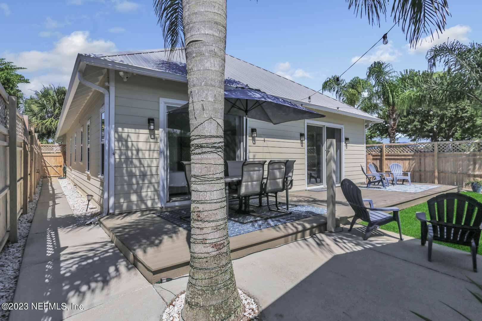 3081 Pullian Court Jacksonville Beach, FL 32250 - Photo 48 of 56 a view of a patio with table and chairs with wooden fence and plants