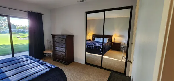 a bedroom with a bed a large window and walk in closet