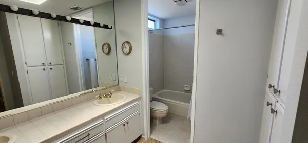a bathroom with a double vanity sink toilet mirror and shower