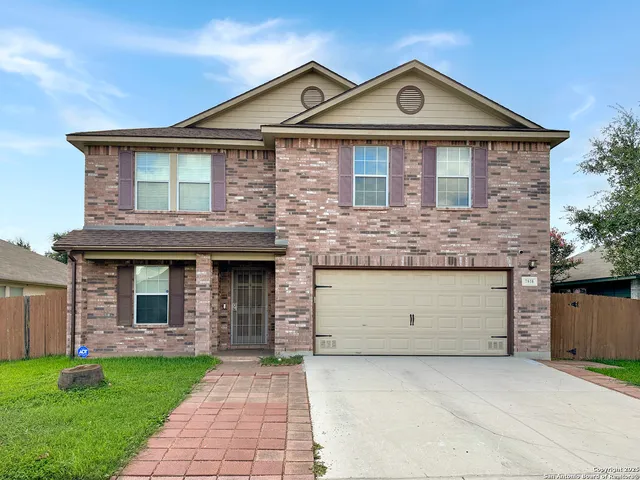 a front view of a house with a garden and garage