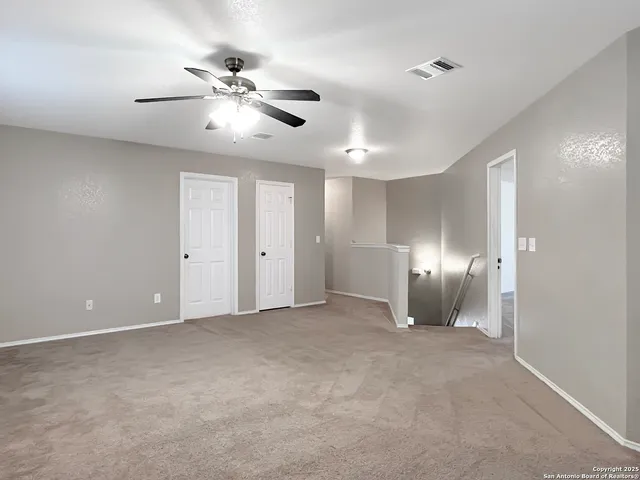 a view of an empty room with a ceiling fan