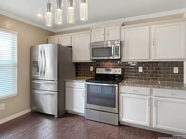 a kitchen with stainless steel appliances a refrigerator stove and microwave