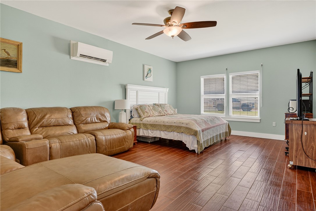 838 Rattlesnake Point Road Rockport, TX 78382 - Photo 27 of 40 a bedroom with a large bed a flat tv screen and a dresser