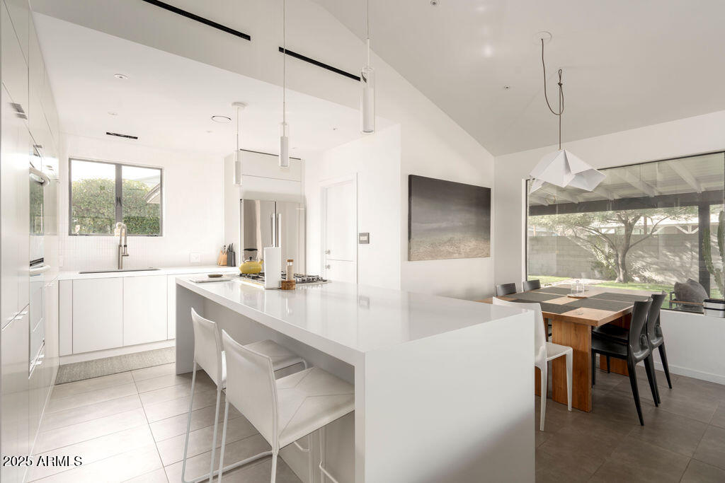 4530 North 9th Avenue Phoenix, AZ 85013 - Photo 4 of 35 a kitchen with a sink a stove a dining table and chairs