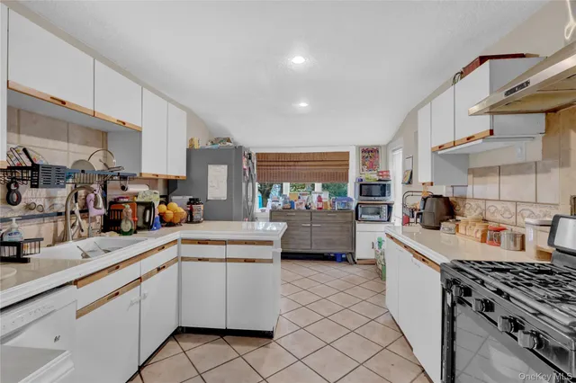 a kitchen that has a lot of cabinets in it and appliances