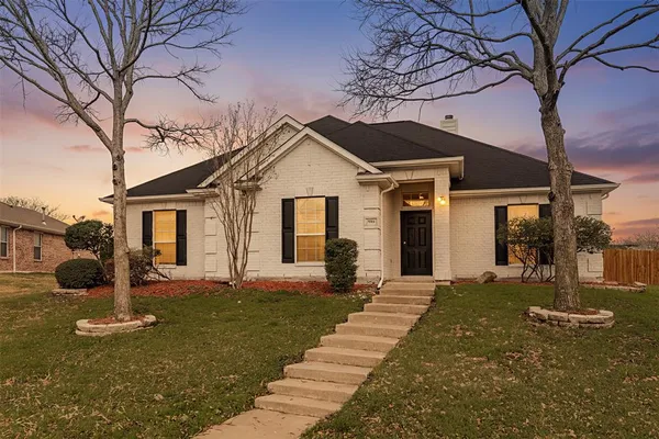 a front view of a house with a yard and potted plants