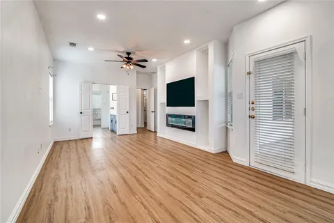 a view of a livingroom with wooden floor and a ceiling fan