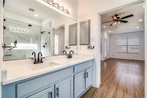 a bathroom with a sink double vanity granite and a mirror