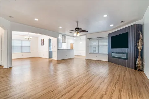 a view of a livingroom with a flat screen tv wooden floor and a window