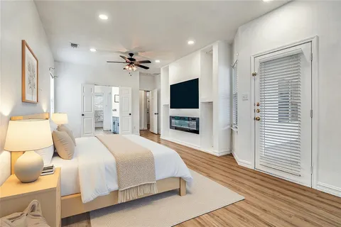 a spacious bedroom with a bed and a flat screen tv