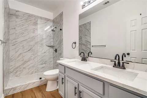 a bathroom with a sink a toilet and shower