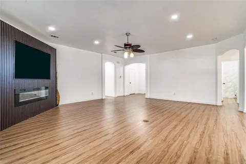 a view of a livingroom with wooden floor and a ceiling fan