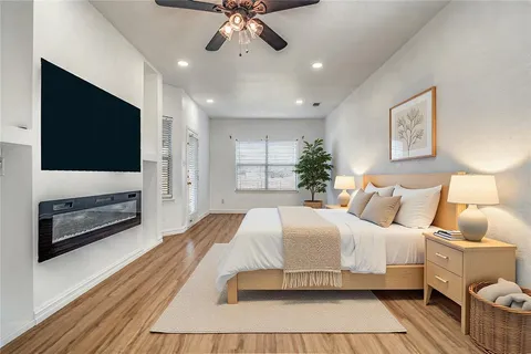a bedroom with a large bed a flat tv screen and a dresser